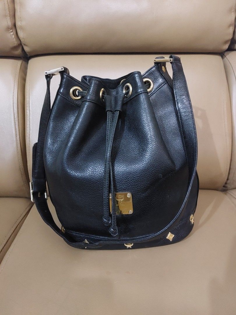 MCM Germany Black Leather Bucket Bag (Category: Luxury Bags & Wallets) located in Las Pinas. Submitted by jmproperties (Listing ID 1441781276, Image 1). Description: - Authentic MCM bucket bag Germany - Color: Black leather - Hardware: Gold size : large - Closure: Drawstring - Strap: Adjustable - A timeless addition to your collection Details: Genuine pebbled leather exterior Gold-tone hardware and logo plaque Drawstring bucket closure Adjustable