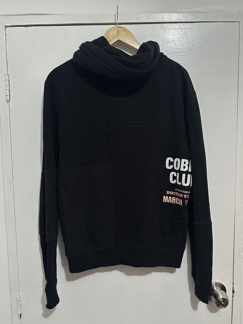 MCQ "FEAR NOTHING" Black Zip-Up Hoodie (Category: Hoodies) located in Manila. Submitted by markjason420 (Listing ID 1441867775, Image 2). Description: - MCQ Black Zip-Up Hoodie - 'FEAR NOTHING' graphic on front with names - 'COBRA CLUB' graphic on back - Unique panel design on sleeves - Full zip closure - Comfortable and stylish.