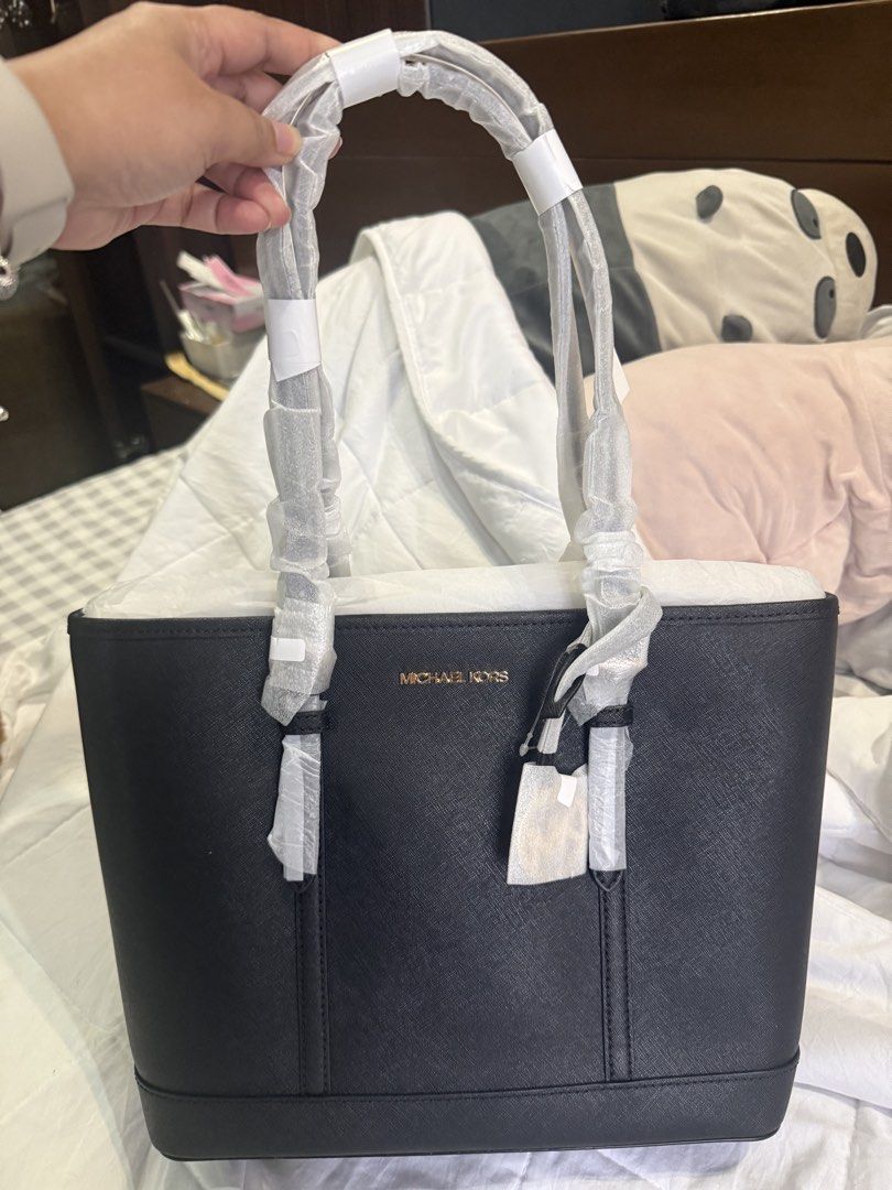 Michael Kors Black Leather Tote Bag (Category: Tote Bags) located in Manila. Submitted by air0526 (Listing ID 1441851185, Image 3). Description: - Classic black Michael Kors tote bag - Genuine Saffiano leather - Elegant gold-tone hardware - Ample interior space for essentials - Handles still in original protective plastic - Comes with original tags - Ideal for everyday use.