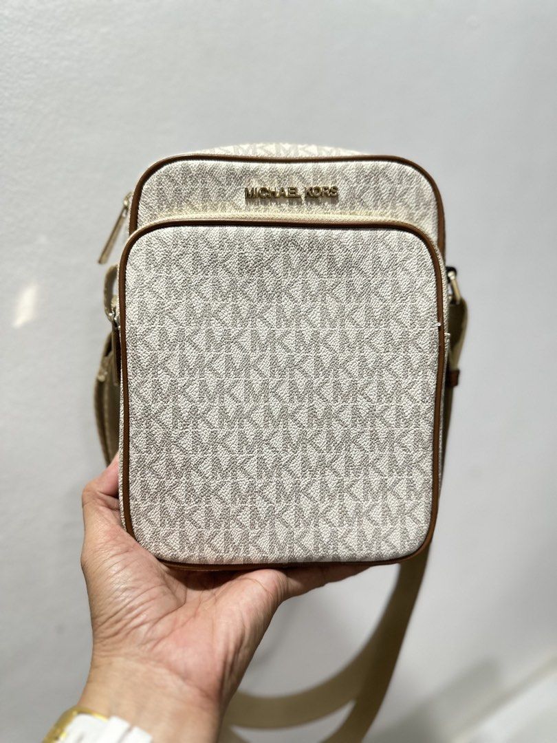 MICHAEL Michael Kors Jet Set Travel Medium Flight Bag (Category: Luxury Bags & Wallets) located in Bulacan. Submitted by brandnewprelovedstuffatbp. (Listing ID 1441786954, Image 1). Description: - Authentic Michael Kors crossbody bag - Signature beige and white MK print - Stylish brown leather trim - Adjustable strap for comfortable wear - Two secure zip compartments - Ideal for everyday use, fitting phone, wallet, and keys.