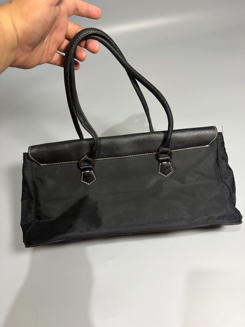 Prada Black Nylon Leather Trim Tote Bag (Category: Luxury Bags & Wallets) located in General Trias. Submitted by happystorm_b8e70b (Listing ID 1441795625, Image 2). Description: - Classic black Prada tote bag - Made in Italy - Mix of durable nylon and premium leather - Secure front clasp closure - Interior zippered pocket - Spacious for essentials - Ideal for daily use or travel.