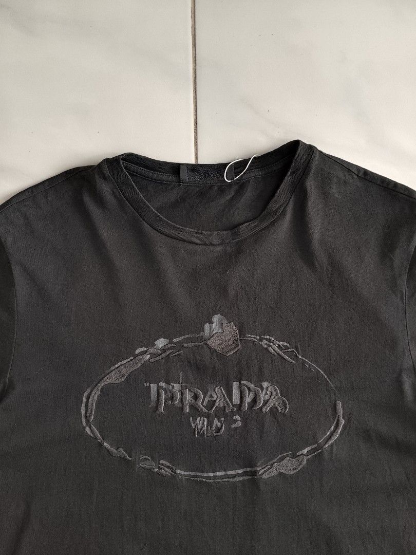 Prada Milano T-Shirt Black (Category: Tshirts & Polo Shirts ) located in Bambang. Submitted by kate_zian (Listing ID 1441806238, Image 2). Description: Width: 19 Length: 26 Size on tag: 30 Color Rate: 9.8/10 Condition: 9.5/10 Issue: check photos above (sleeve part).