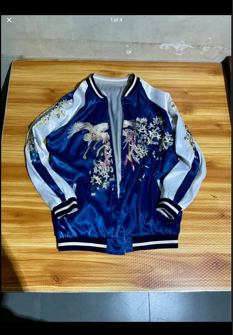 Reversible Embroidered Bomber Jacket (Category: Coats, Jackets and Outerwear) located in Manila. Submitted by irthrift (Listing ID 1441970212, Image 1). Description: - Cool reversible bomber jacket - Vibrant blue side with intricate bird and floral embroidery - Sleek light blue and beige satin side - Features ribbed cuffs and hem - Perfect for creating a statement look - Ideal for layering.