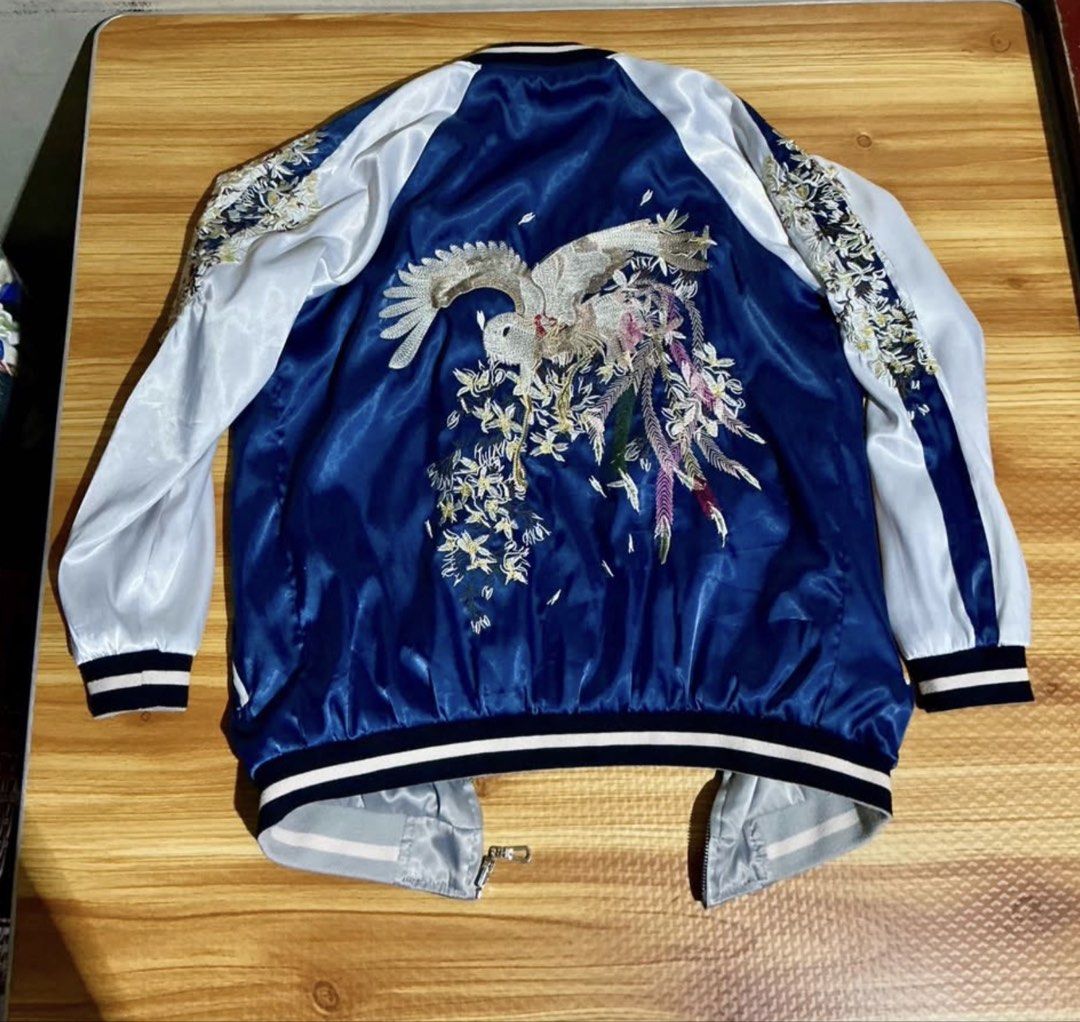 Reversible Embroidered Bomber Jacket (Category: Coats, Jackets and Outerwear) located in Manila. Submitted by irthrift (Listing ID 1441970212, Image 2). Description: - Cool reversible bomber jacket - Vibrant blue side with intricate bird and floral embroidery - Sleek light blue and beige satin side - Features ribbed cuffs and hem - Perfect for creating a statement look - Ideal for layering.