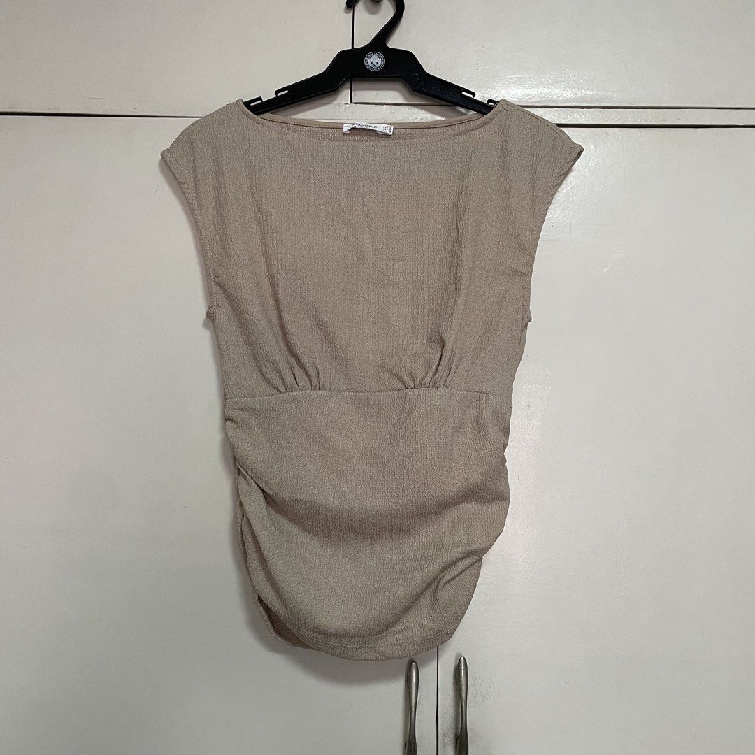 Stradivarius Ruched Cap Sleeve Top Size S (Category: Blouses) located in Manila. Submitted by stuffbyaly (Listing ID 1441906151, Image 1). Description: - Stradivarius Cap Sleeve Top - Color: Beige/Tan - Features: Ruching detail on sides and front - Fabric: Textured appearance - Size: Small Feel free to message if you have any questions or concerns! Please expect replies within 24 hours. Thank you!.