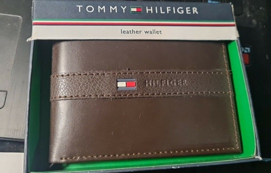 Tommy Hilfiger Brown Leather Bifold Wallet (Category: Wallets & Card holders) located in Angeles City. Submitted by ejhere (Listing ID 1441966154, Image 1). Description: - Genuine Tommy Hilfiger brown leather bifold wallet - Classic design with strap detail and iconic logo/flag emblem - Includes original Tommy Hilfiger box - Ideal for everyday carry and use.
