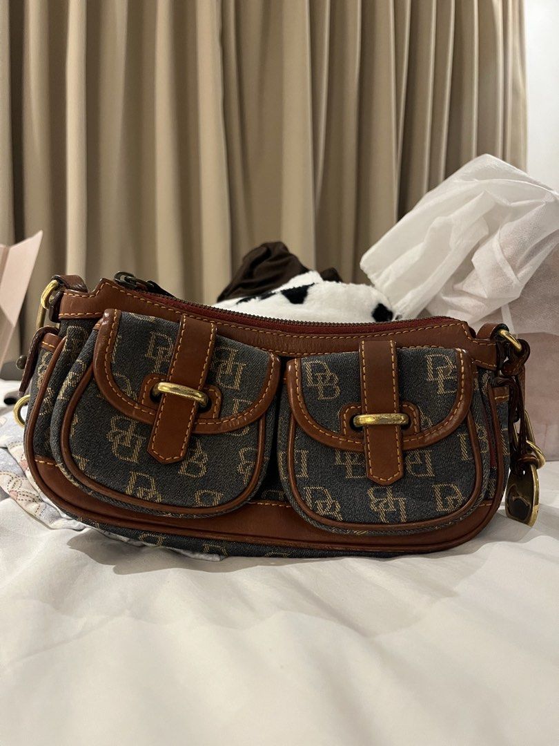 Vintage Y2K Dooney & Bourke Monogram Shoulder Bag (Category: Shoulder Bags) located in Muntinlupa City. Submitted by chiccamnl (Listing ID 1441877596, Image 1). Description: - Cute Dooney & Bourke shoulder bag - Classic DB monogram pattern - Brown leather trim - Gold hardware - Two front pockets with buckle closures - Great for everyday use - A classic addition to your collection.