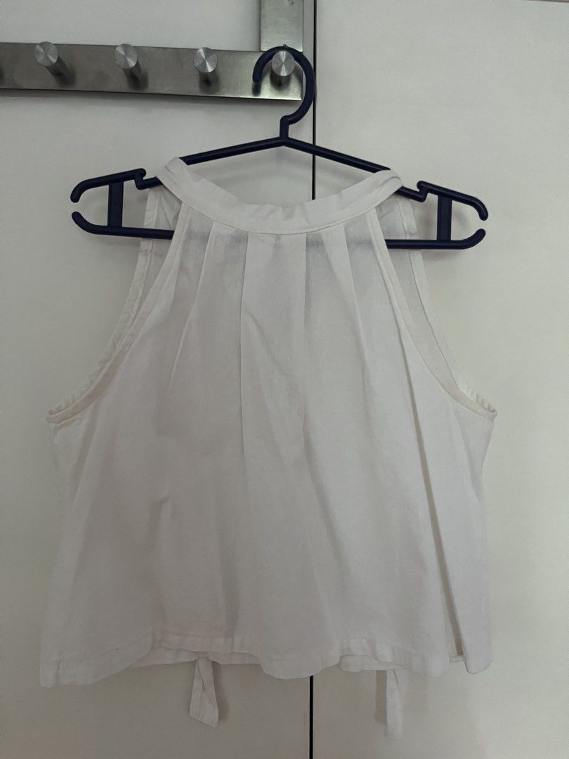 White Sleeveless Halter Neck Top with Tie Back (Category: Sleeveless) located in Quezon City. Submitted by mbaut (Listing ID 1441863273, Image 1). Description: - Sleeveless white halter top - Features flattering front pleats - Stylish open back with tie detail - Versatile piece for casual or dressed-up looks - Simple and clean design.