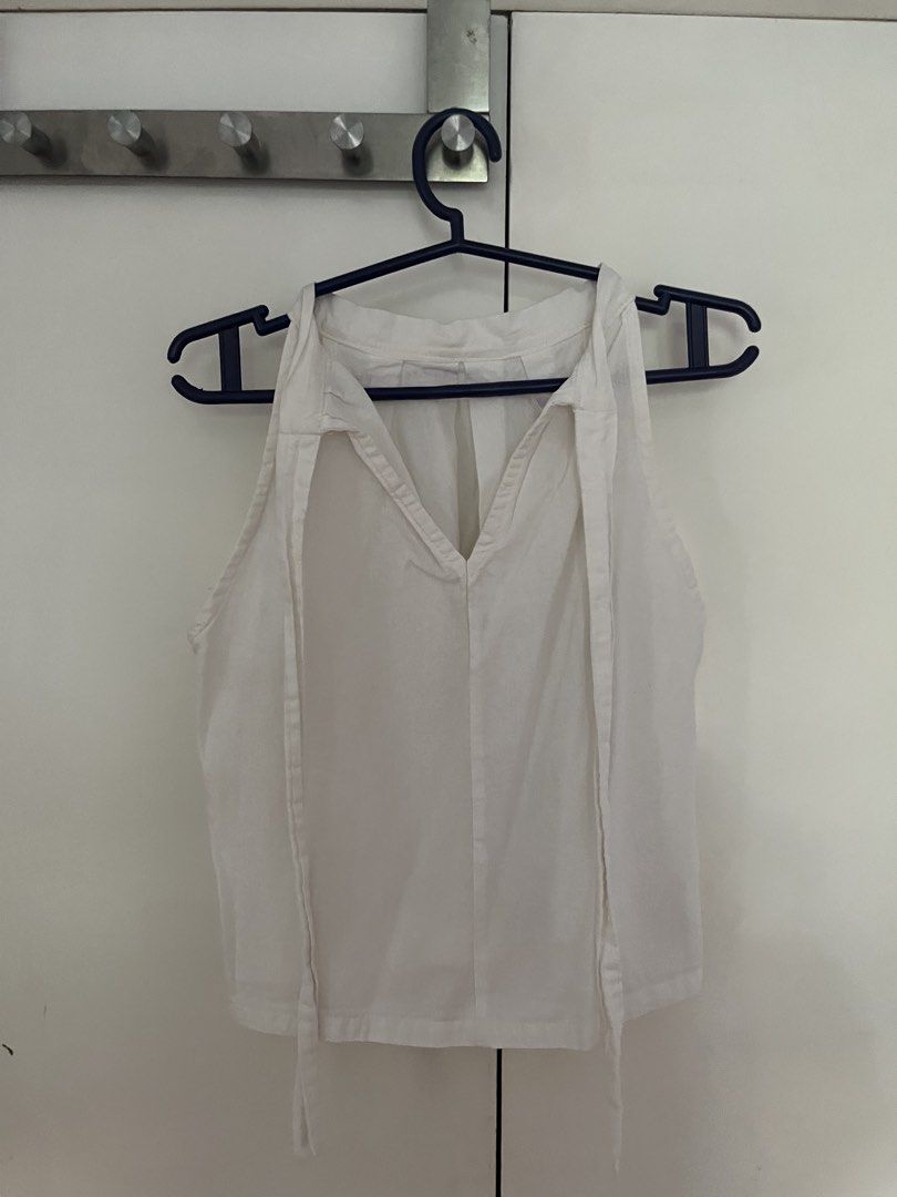 White Sleeveless Halter Neck Top with Tie Back (Category: Sleeveless) located in Quezon City. Submitted by mbaut (Listing ID 1441863273, Image 2). Description: - Sleeveless white halter top - Features flattering front pleats - Stylish open back with tie detail - Versatile piece for casual or dressed-up looks - Simple and clean design.