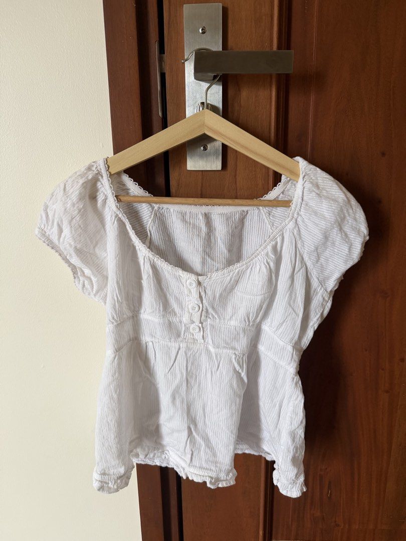 White Striped Puff Sleeve Top with Buttons (Category: Blouses) located in Manila. Submitted by prelovedbygabrielle988 (Listing ID 1441834054, Image 1). Description: - Adorable white top with subtle pinstripes - Features short puff sleeves - Flattering sweetheart neckline - Convenient button-up front - Trendy ruffled hem detail - Ideal for everyday casual wear.