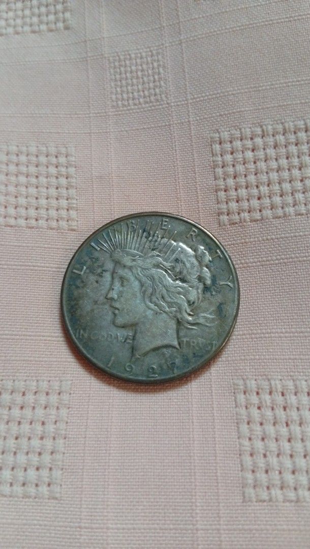 1927 Peace Silver Dollar Coin (Category: Currency) located in Quezon City. Submitted by jojoscollectibles (Listing ID 1441986418, Image 1). Description: - Authentic 1927 Peace Silver Dollar coin, Philadelphia mint - Features iconic Lady Liberty on the obverse - Showcases a majestic eagle on the reverse - A classic and sought-after American silver dollar - Ideal addition to any coin collection - Feel free to ask any questions!.