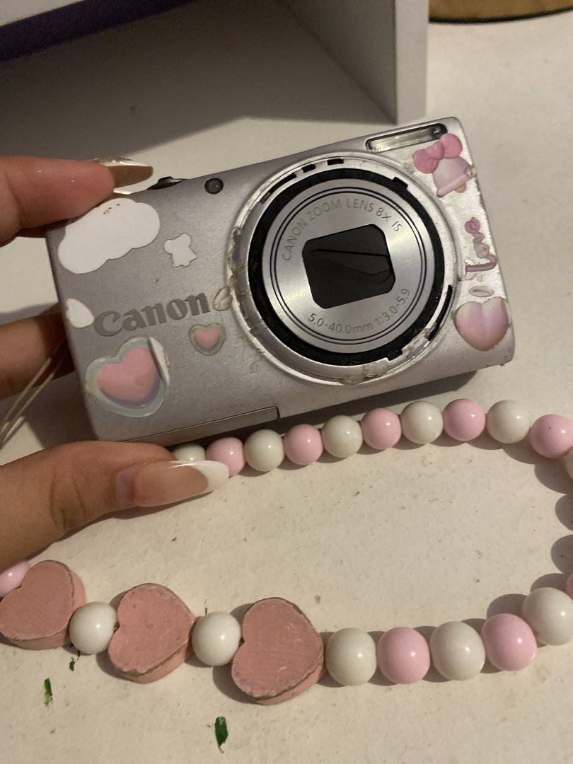 Canon Digital Camera with 8x Optical Zoom and Charm Strap (Category: Cameras) located in Agdangan. Submitted by ishameicnd (Listing ID 1442110360, Image 1). Description: - Canon digital camera - 8x optical zoom lens - Comes with fun pink and white beaded charm strap - Includes 4GB Toshiba SDHC memory card ISSUE: LENS ERROR RFS: (tinamad na mag paayos) Kunin nyo na guys malinaw ang kuha, 16 mp, working ang flash PRICE + SHIPPING FEE MOD: Gcash.