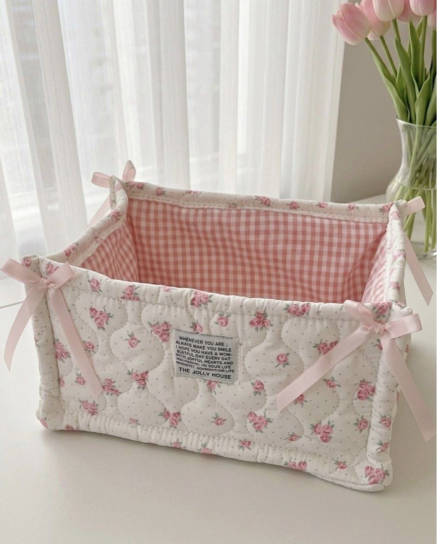 Coquette Floral Storage Basket (Category: Storage Boxes & Baskets) located in Manila. Submitted by kellemirah (Listing ID 1442148218, Image 1). Description: Size: (14cm x 28cm x 19cm) - Adorable quilted storage basket. - Features a charming pink floral pattern exterior. - Lined with a sweet pink gingham fabric. - Includes cute pink ribbon ties on each corner. - Ideal for organizing small items on shelves or desks..