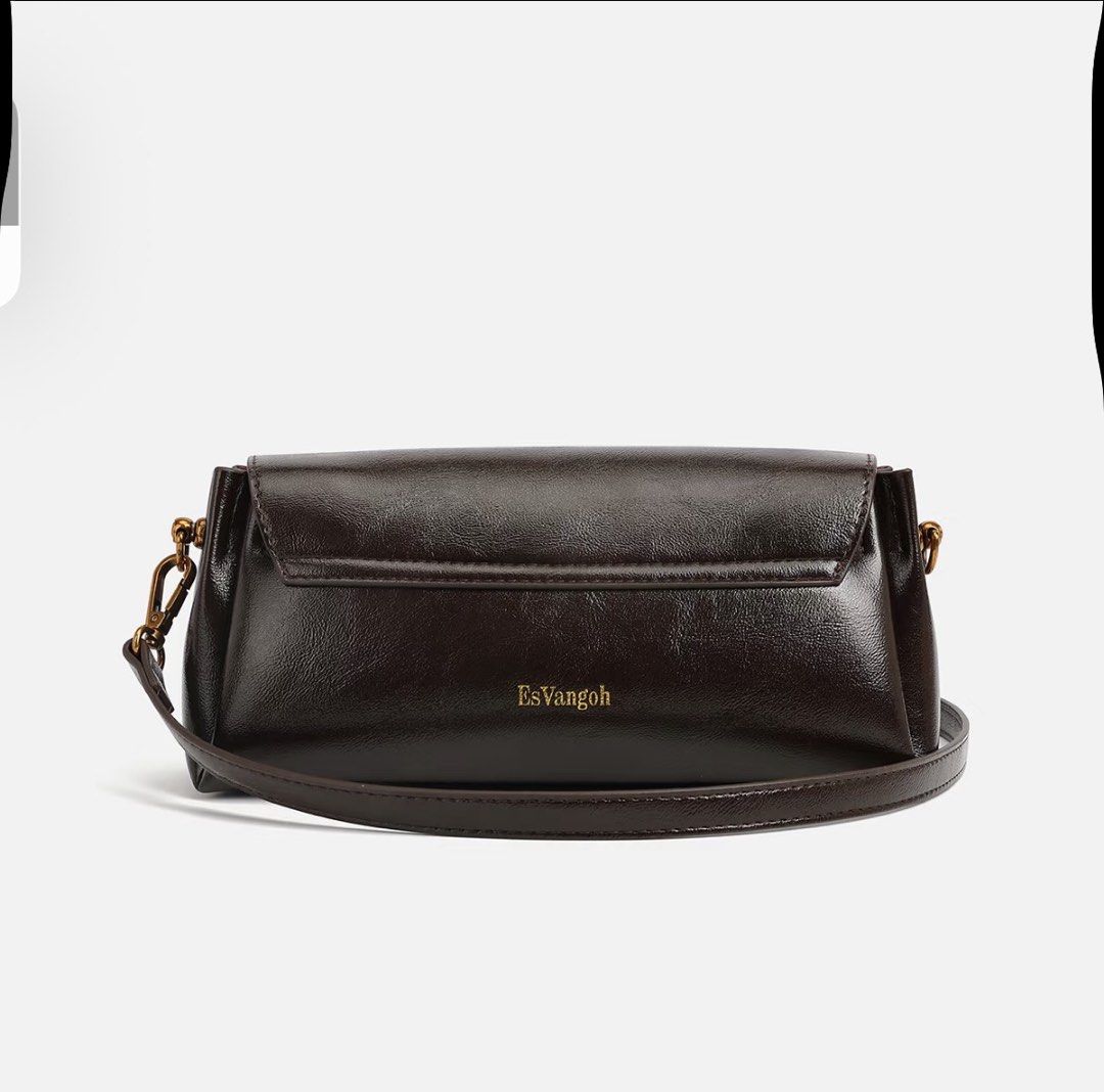 EsVangoh Dark Brown Leather Shoulder Bag (Category: Shoulder Bags) located in Manila. Submitted by pinga_crystal (Listing ID 1442135535, Image 3). Description: - Dark brown leather shoulder bag - Features a circular emblem on the front - Brand name 'EsVangoh' subtly displayed on the back - Comes with a detachable strap for versatile wear - Phone included in photos for accurate size comparison.