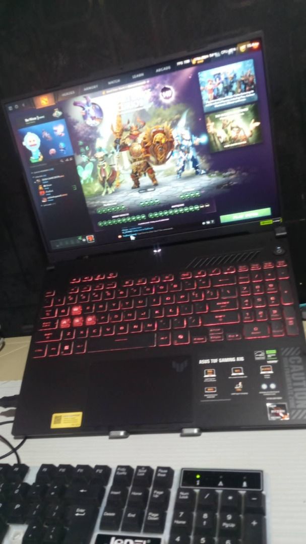 Gaming Laptop (Category: Laptops & Notebooks) located in Pila. Submitted by john291999 (Listing ID 1442152843, Image 1). Description: - ASUS TUF Gaming A16 Laptop - Ideal for gaming sessions - Red backlit keyboard for a cool gaming aesthetic - Screen displays a game interface (likely Dota 2) - Ready for a new owner.