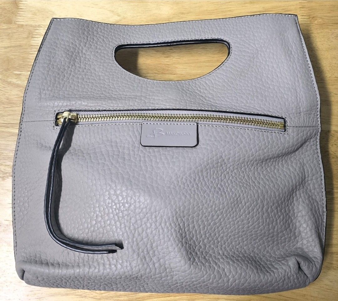 Grey Leather Foldover Clutch Bag with Zip Pocket (Category: Clutches) located in Makati City. Submitted by patimay (Listing ID 1442081762, Image 1). Description: - Grey pebbled leather clutch - Front zip pocket - Cut-out top handle - Foldable design - Gold-tone zipper - Leather tassel zipper pull detail - Ideal for evening wear or as a statement piece.