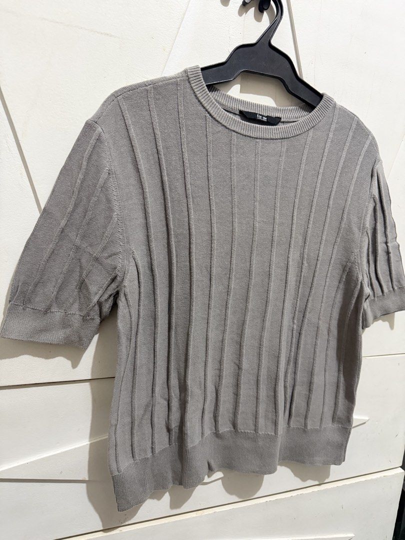 Grey Ribbed Knit Short Sleeve Top (Category: Blouses) located in Muntinlupa City. Submitted by jaja.0903 (Listing ID 1442124491, Image 2). Description: - Grey short sleeve knit top - Vertical ribbed detailing - Crew neck - Slightly cropped length - Subtle puff sleeve detail - Versatile: pairs easily with jeans or skirts.