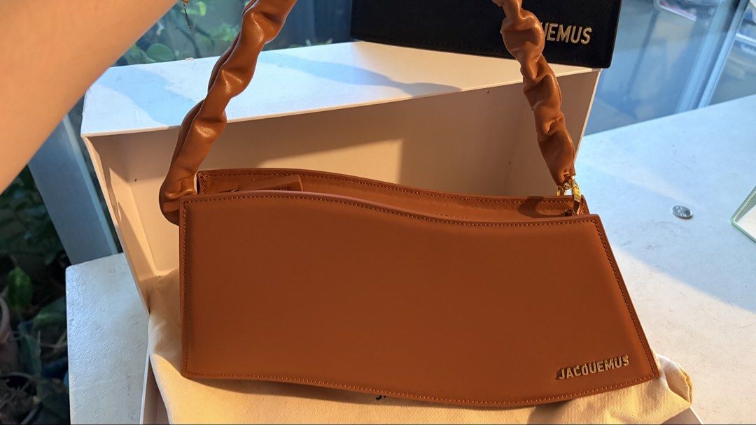 Jacquemus Le Vague Bag (Category: Luxury Bags & Wallets) located in Manila. Submitted by jocelynsnight (Listing ID 1442071471, Image 1). Description: Jacquemus Le Vague Bag ✨ Selling my authentic Jacquemus Le Vague wave shoulder bag in beautiful cognac brown leather. Condition: 9.5/10. Carried only 1-2 times max. No noticeable damage or visible flaws. Includes: Original box and dust bag. Absolute dream bag, just trying to downsize my collection! 