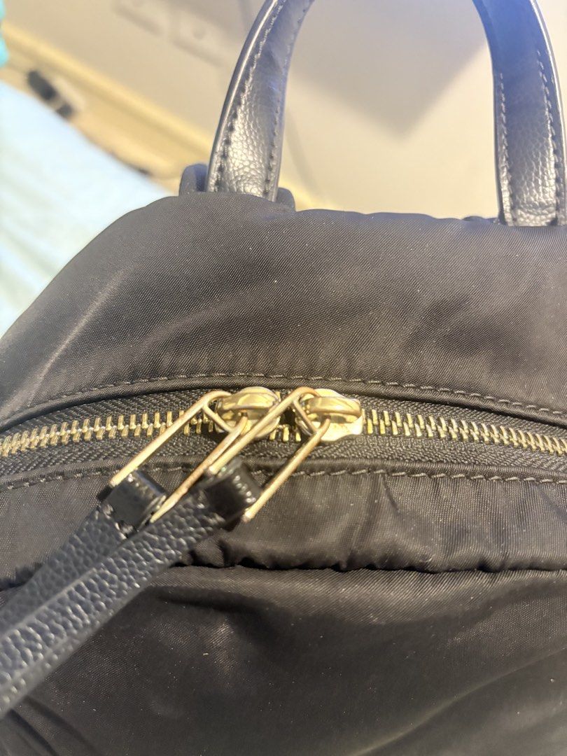 Kate Spade New York Black Nylon Backpack (Category: Backpacks) located in Manila. Submitted by budgetpreloveditems (Listing ID 1442106051, Image 3). Description: - Authentic Kate Spade backpack in classic black. - Crafted from high-quality nylon with elegant leather accents. - Features stylish gold-tone hardware on all zippers. - Includes a convenient top handle and adjustable shoulder straps for comfortable carrying. - Front zippered pocket for 