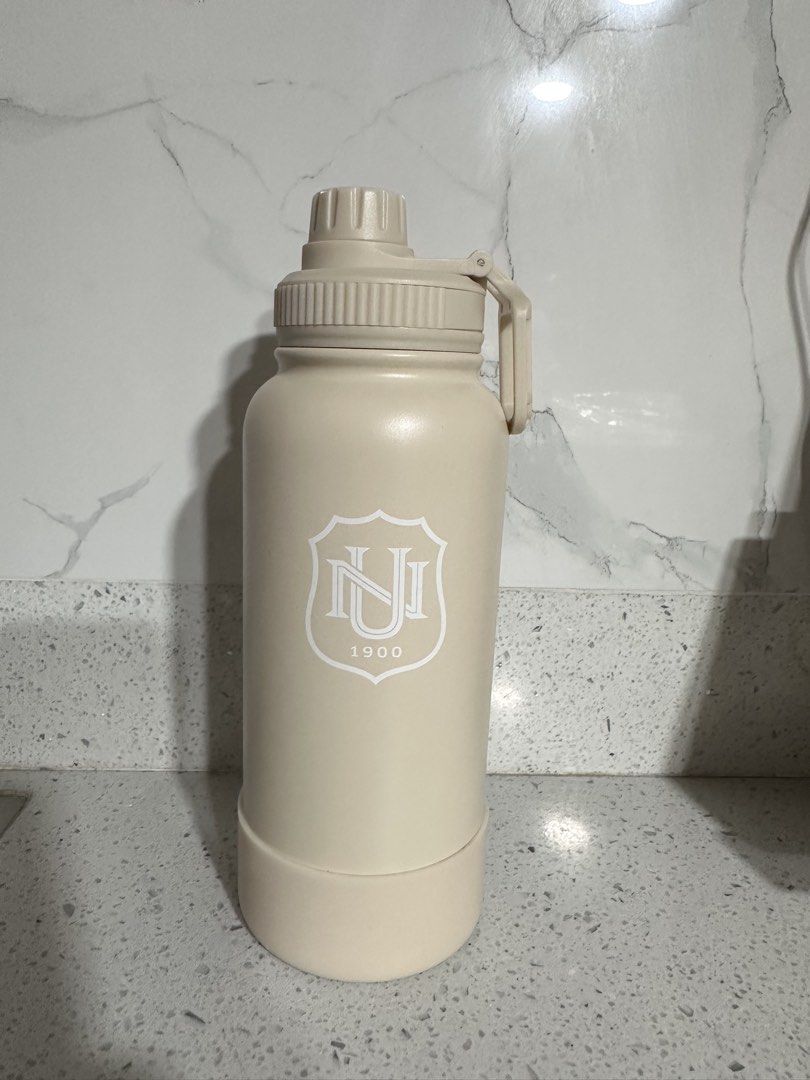NU Hydrofresh Stainless Steel Water Bottle with Sport Cap (Category: Water Bottles & Tumblers) located in Lipa City. Submitted by luciv (Listing ID 1442089208, Image 1). Description: - Cream colored Hydrofresh stainless steel water bottle - Insulated design to keep drinks at the perfect temperature - Includes a sport cap for easy sipping and a protective boot for the base - Features a 'NJ 1900' logo - Ideal for staying hydrated while on the move 