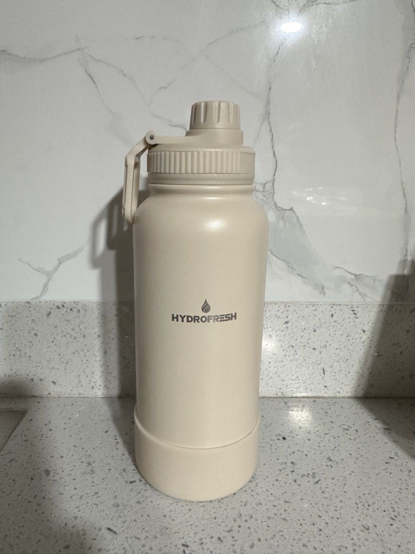 NU Hydrofresh Stainless Steel Water Bottle with Sport Cap (Category: Water Bottles & Tumblers) located in Lipa City. Submitted by luciv (Listing ID 1442089208, Image 2). Description: - Cream colored Hydrofresh stainless steel water bottle - Insulated design to keep drinks at the perfect temperature - Includes a sport cap for easy sipping and a protective boot for the base - Features a 'NJ 1900' logo - Ideal for staying hydrated while on the move 