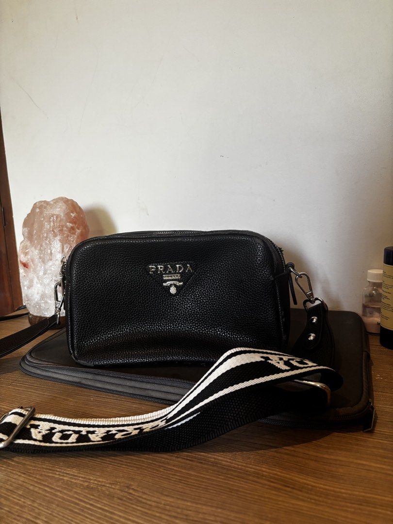 Prada Black Leather Crossbody Bag with White Strap (Category: Luxury Bags & Wallets) located in Bacoor. Submitted by ysadane (Listing ID 1442006951, Image 1). Description: - Silver-tone hardware - Comes with a black and white branded strap - Two working main zippered compartments - Flaws: some leather came off (see photos).