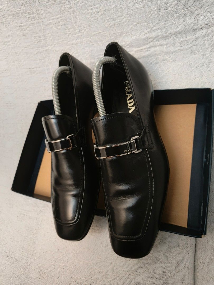 Prada Black Leather Loafers with Silver Buckle (Category: Dress Shoes) located in Makati City. Submitted by emem.pre.owned.ph (Listing ID 1442040636, Image 2). Description: - Classic black leather loafers - Elegant silver buckle detail on the front - Chic square toe design - Perfect for both formal occasions and casual outings.