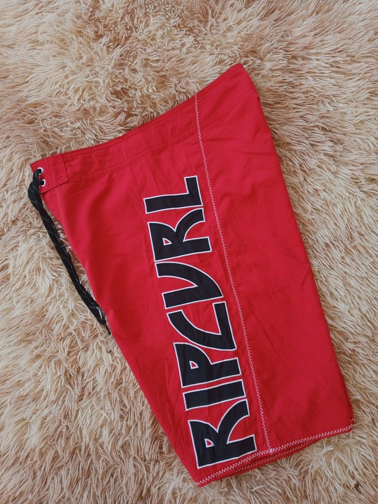 Ripcurl Red Board Shorts with Lightning Bolt Design (Category: Activewear) located in Boston. Submitted by johnpaulvi30029 (Listing ID 1442024620, Image 2). Description: - Red Ripcurl board shorts - Classic Ripcurl logo on the side - Lightning bolt graphic and 'RC69' on front pocket - Zip pocket closure - Drawstring waist - Ideal for beach or pool.