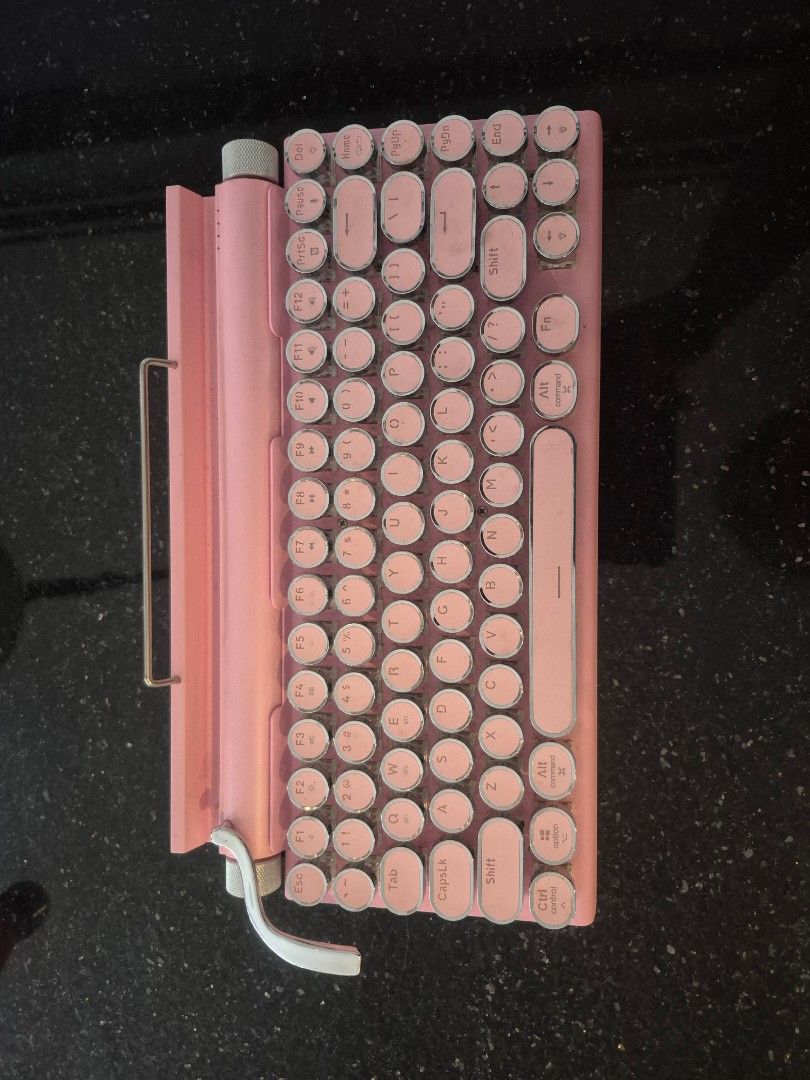 Taiahiro Retro Mechanical Bluetooth Keyboard Pink Typewriter Style (Category: Computer Keyboard) located in Taguig. Submitted by firesale123 (Listing ID 1442026715, Image 1). Description: - Charming pink retro mechanical keyboard - Unique typewriter-style keys - Seamless Bluetooth connectivity - Perfect for iPads and tablets - Built-in device stand for convenience - Sold as is.