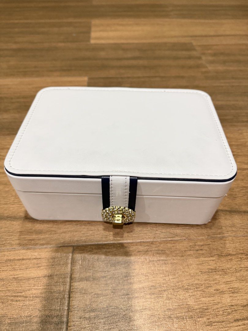 White Jewelry Box with Rhinestone Clasp (Category: Accessory Holder, Box & Organizers) located in Paranaque City. Submitted by lovedstuffby_ang (Listing ID 1442066272, Image 1). Description: - Chic white jewelry box - Features a navy blue and white ribbon detail - Gold-tone clasp adorned with sparkling rhinestones - Ideal for keeping your accessories organized.