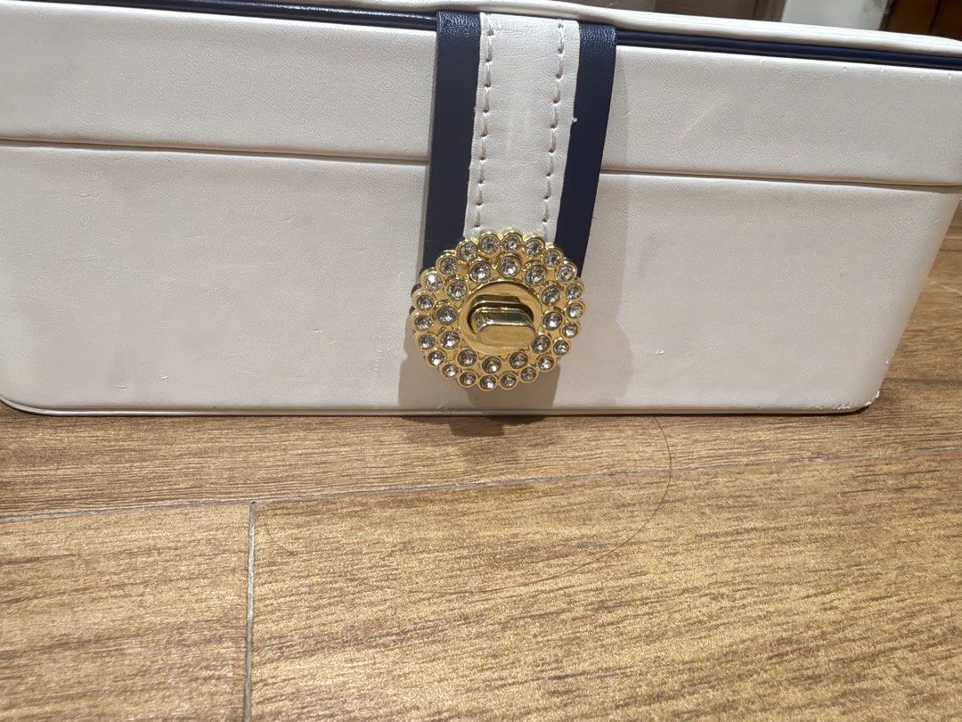 White Jewelry Box with Rhinestone Clasp (Category: Accessory Holder, Box & Organizers) located in Paranaque City. Submitted by lovedstuffby_ang (Listing ID 1442066272, Image 2). Description: - Chic white jewelry box - Features a navy blue and white ribbon detail - Gold-tone clasp adorned with sparkling rhinestones - Ideal for keeping your accessories organized.