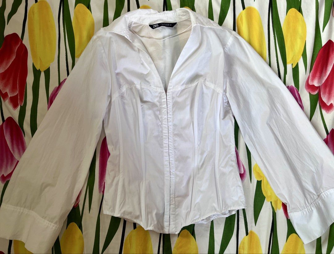 ZARA White Corset Style Button-Up Shirt (Category: Shirts) located in Manila. Submitted by oddstorm_9d6c74 (Listing ID 1441989760, Image 1). Description: - Zara white button-up shirt - Size S (estimated) - Corset-style fit with shaping darts - Long sleeves with button cuffs - Front zip closure.