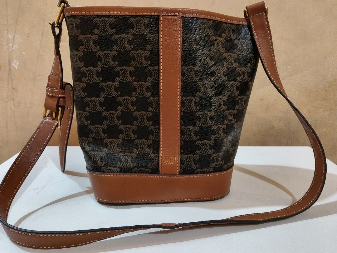 Celine Triomphe Canvas Bucket Bag (Category: Luxury Bags & Wallets) located in Lapu Lapu. Submitted by tanvm1221 (Listing ID 1442326412, Image 1). Description: - Classic Celine bucket bag in iconic Triomphe canvas. - Features elegant brown and tan leather trim. - Adjustable strap for customized comfort. - A timeless and versatile piece for any wardrobe. - Ideal for everyday styling and practicality..