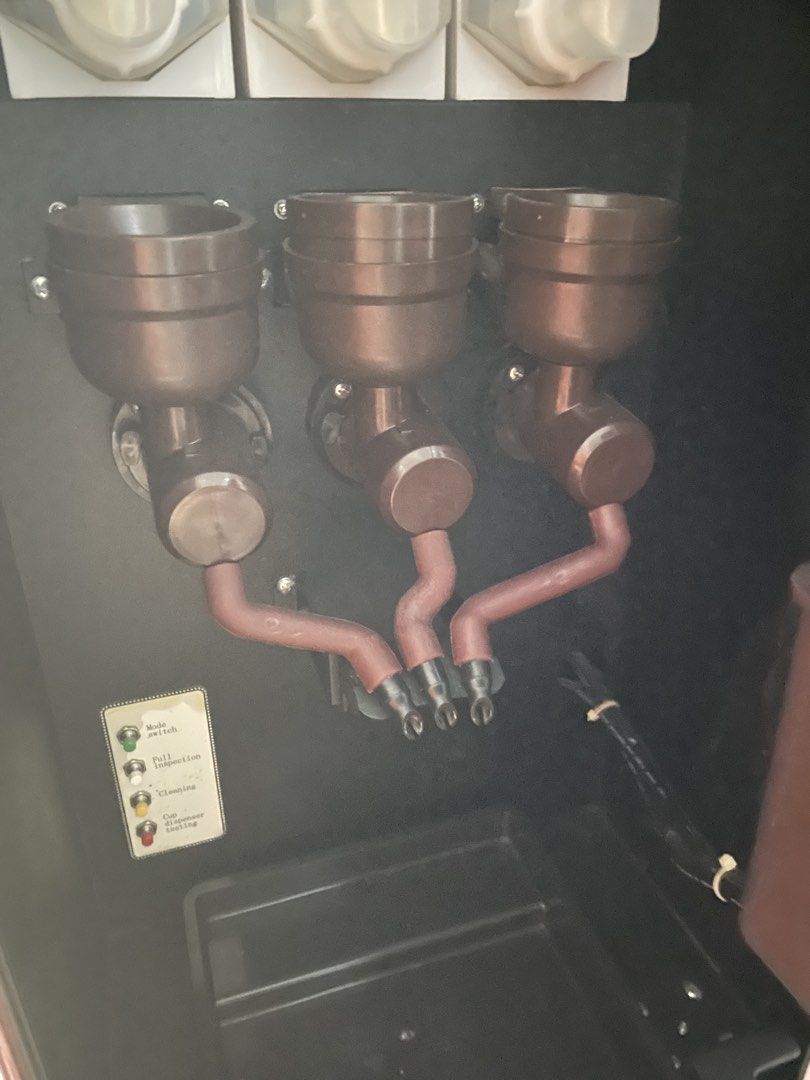 Coffee Vendo Machine Dosing Hoppers and Tubes (Category: Coffee Machines & Makers) located in Quezon City. Submitted by lanqcqc (Listing ID 1442189964, Image 1). Description: - Three dosing hoppers with connecting tubes - Likely for a commercial coffee machine - Features operational indicators: Mode Switch, Pull Handpiece Icon, Cleaning, and Cup Placement/Emptying.