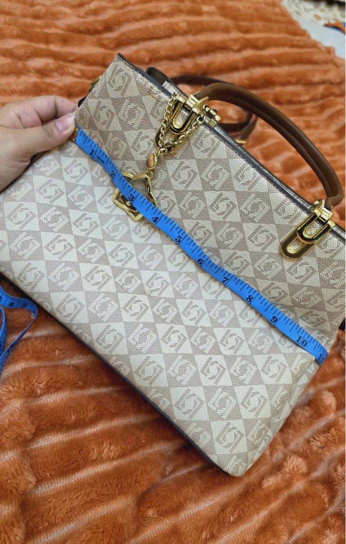 Designer Monogram Handbag with Shoulder Strap (Category: Luxury Bags & Wallets) located in Manila. Submitted by flicker_33 (Listing ID 1442311450, Image 2). Description: - Stylish beige and brown monogram handbag - Versatile with top handles and a detachable shoulder strap - Organized interior with multiple compartments and a zippered pocket - Adorable bear charm included - Convenient size: approximately 10 inches wide.