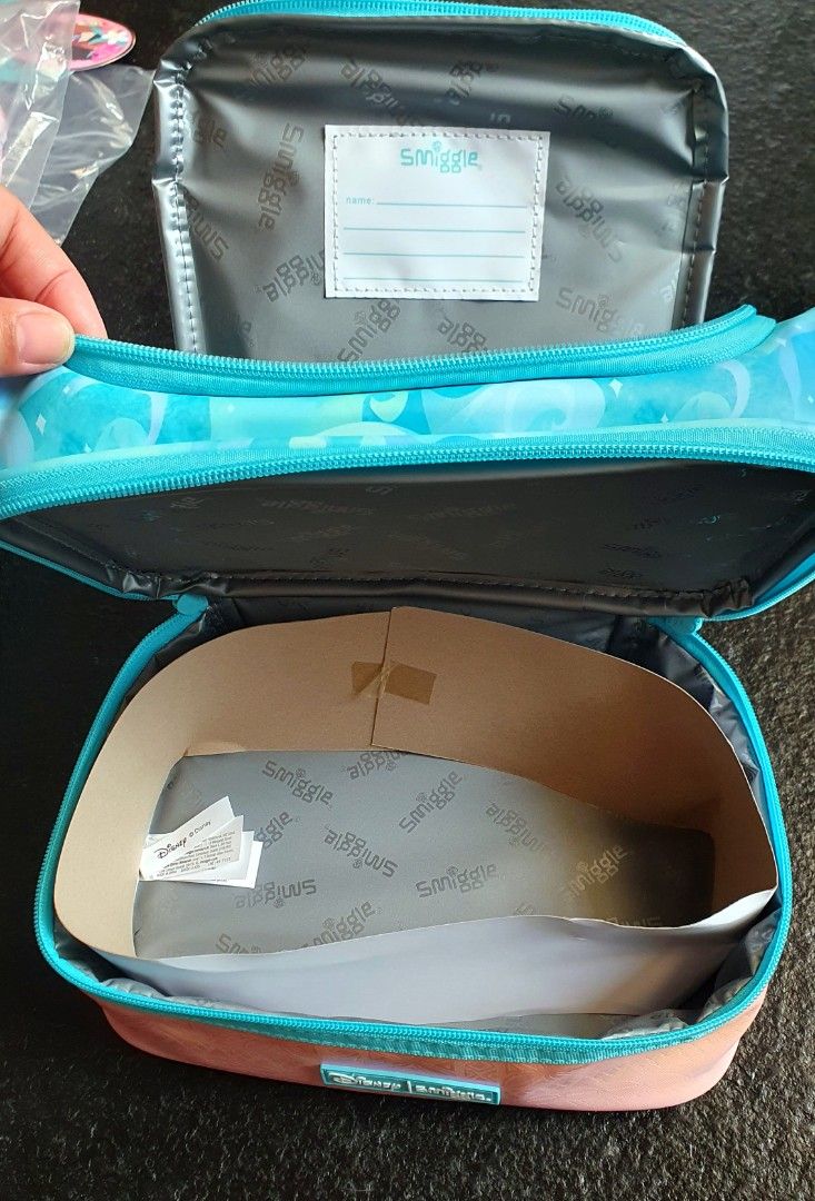 Disney Smiggle Moana Double Decker Lunch Box (Category: Food Organization & Storage) located in San Juan City. Submitted by leyuri_shop2025 (Listing ID 1442172745, Image 3). Description: Smiggle x Disney Moana Double Decker Lunch Box Waterproof material Features Moana print, insulated lining, name label, and rope handle. Perfect for school or picnics! Dimensions: 15×24.5×15.5 cm.