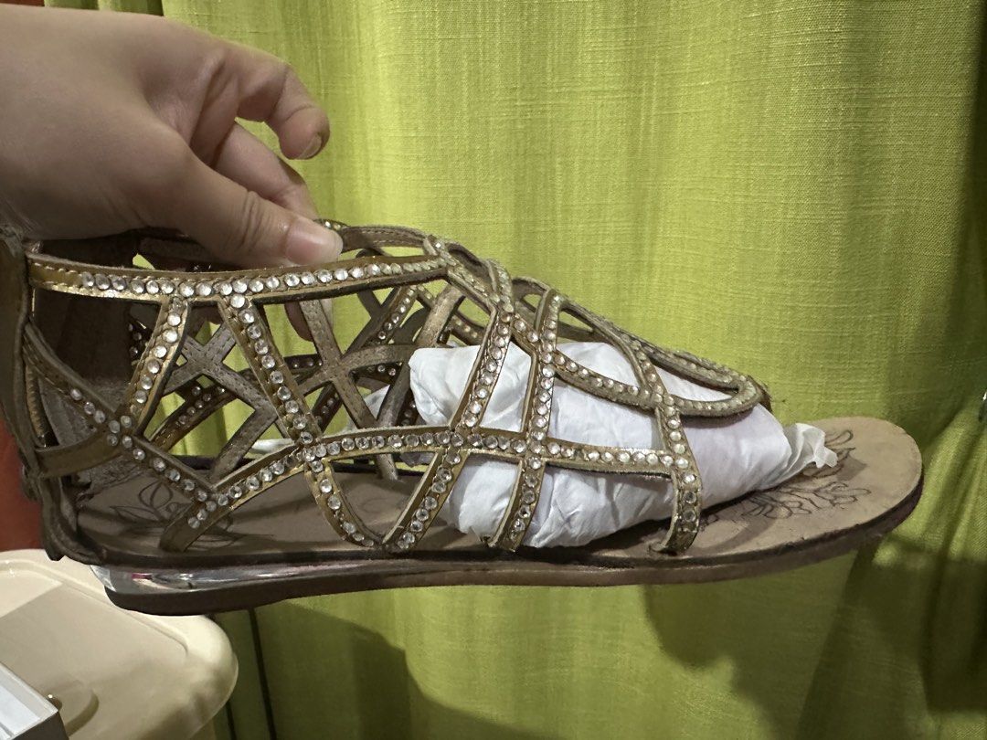 Gold Embellished Gladiator Sandals with Zipper Back (Category: Flats & Sandals) located in Manila. Submitted by shopkriscloset (Listing ID 1442328008, Image 2). Description: - Stunning gold gladiator sandals - Adorned with sparkling rhinestone embellishments - Features a stylish strappy design - Convenient back zipper for easy on and off - Subtle floral imprint on the soles - Ideal for elevating any outfit.