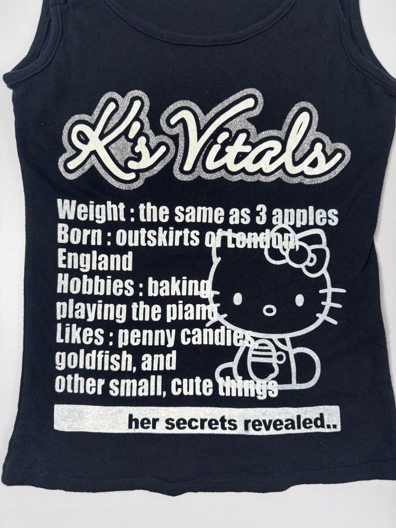 Hello Kitty K's Vitals Black Tank Top (Category: Sleeveless) located in Manila. Submitted by babygirly2k (Listing ID 1442292723, Image 3). Description: - Cute black Kitty tank top - Features 'K's Vitals' graphic with Kitty details - Fun 'K's Vitals' info: Weight (3 apples), Born (outskirts of London), Hobbies (baking, piano), Likes (candies, goldfish, cute things) - Adjustable straps - 100% cotton.