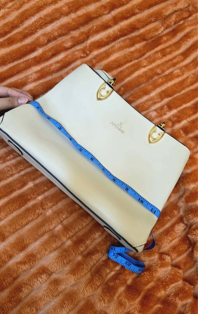JOVANNI White Structured Tote Bag with Gold Hardware (Category: Tote Bags) located in Manila. Submitted by flicker_33 (Listing ID 1442311137, Image 3). Description: - White structured tote bag by JOVANNI - Elegant gold hardware details - Multiple interior compartments for easy organization - Comfortable top handles for carrying - Includes a detachable charm - Generous size: approximately 14 inches wide.