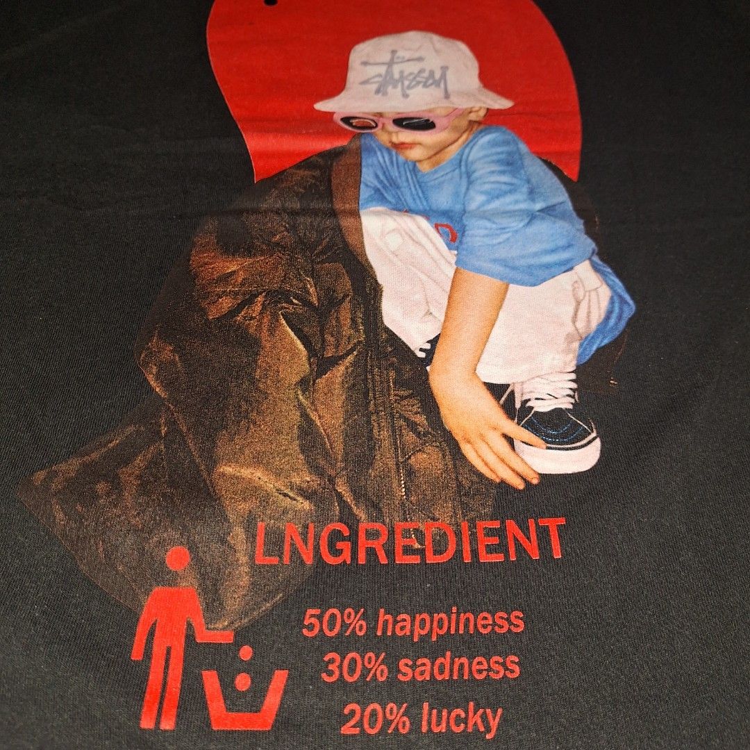 Lngredient Big Graphic Tee. (Category: Tshirts & Polo Shirts ) located in Aroroy. Submitted by rewear_r3volution (Listing ID 1442333364, Image 3). Description: This is a black graphic t-shirt featuring a Japanese-inspired art style, specifically depicting a child wearing a white Stussy bucket hat. Size Medium.
