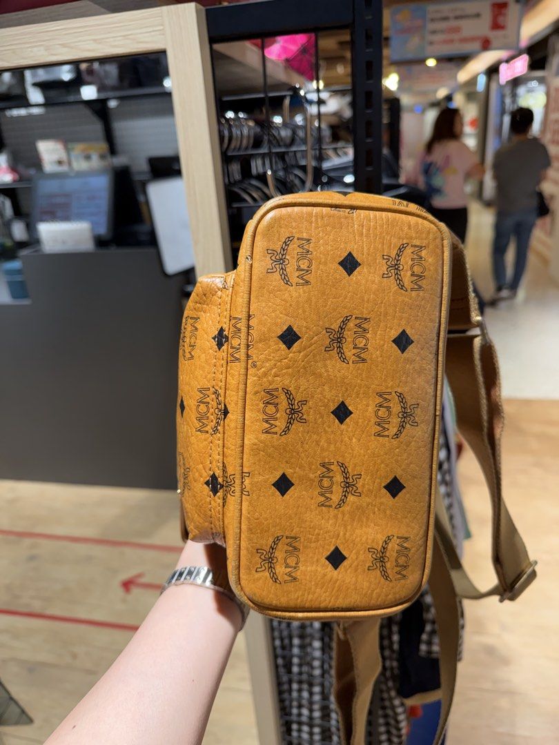 MCM Visetos Mini Backpack Cognac (Category: Backpacks) located in Manila. Submitted by jodiluxegold (Listing ID 1442244978, Image 2). Description: - Classic MCM mini backpack - Iconic Visetos print (brown & black monogram) - Gold-tone hardware with stud details - Adjustable shoulder straps - Zipped main compartment - Front zip pocket - Ideal for everyday use.
