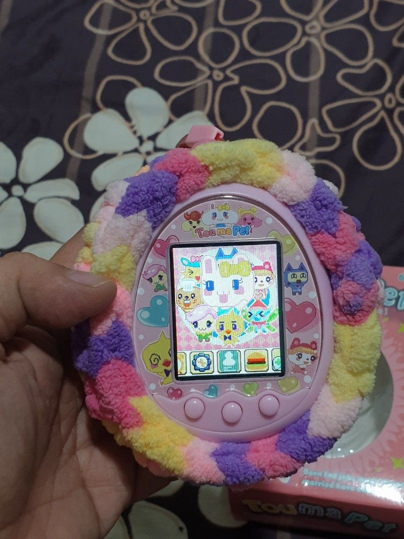 PINK TAMAGOTCHI ELECTRONIC PET TOY WITH FLUFFY COVER (Category: Interactive Toys) located in Malabon City. Submitted by toughMeg (Listing ID 1442243633, Image 1). Description: PINK TAMAGOTCHI ELECTRONIC PET TOY WITH FLUFFY COVER ‼have slightly scratch on screen and minimal rust on battery holder pls see photos..
