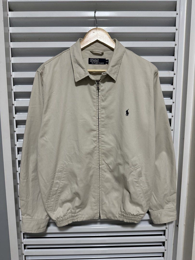 Polo Ralph Lauren Harrington Jacket Beige (Category: Fragrance & Deodorants) located in Pasig City. Submitted by rl.things (Listing ID 1442193478, Image 2). Description: - Classic beige Polo Ralph Lauren jacket - Iconic embroidered polo player logo on chest - Zip-up front closure - Plaid lining inside the collar - Elasticated cuffs and hem - Ideal for layering.