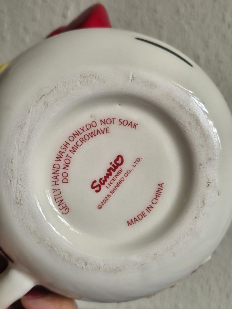Sanrio Hello Kitty Ceramic Mug (Category: Coffee & Tea Tableware) located in Manila. Submitted by belovedbyjess (Listing ID 1442193286, Image 3). Description: - Cute Kitty mug from Sanrio - White ceramic with red bow and lettering - Small chip on handle (visible in last photo) - Perfect for Kitty fans - Hand wash only (do not soak or microwave).
