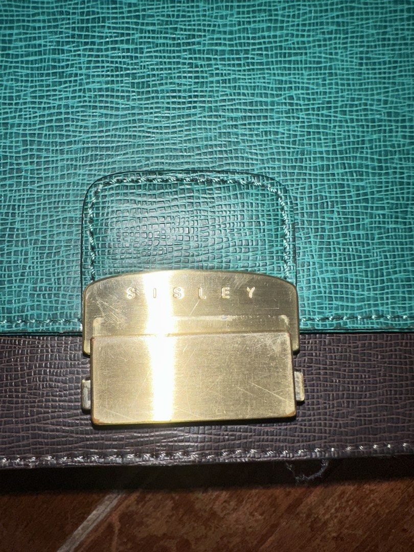 Sisley Shoulder Bag - Teal and Dark Grey (Category: Shoulder Bags) located in Del Monte. Submitted by bittersweetcigs (Listing ID 1442279962, Image 3). Description: - Stylish teal and dark grey shoulder bag - Textured material for a unique look - Secure gold-tone buckle closure with 'Sisley' logo - Adjustable strap for comfortable carrying - Ideal for everyday use.