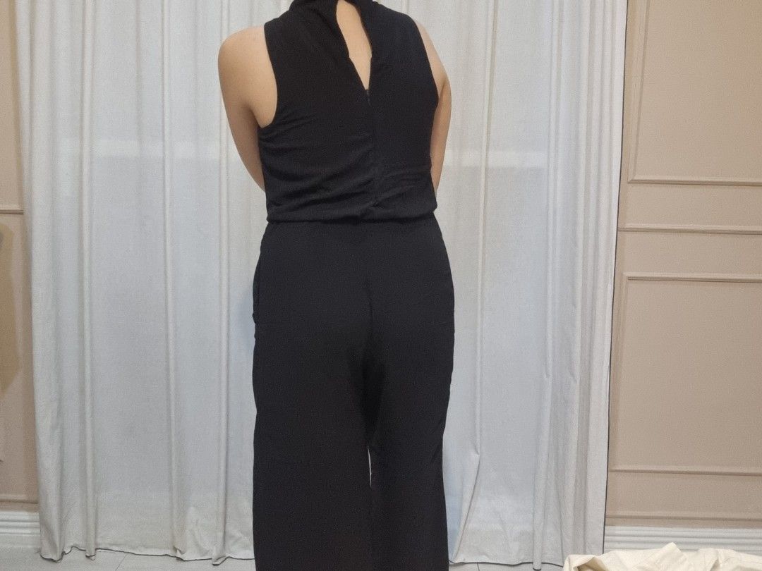 Sleeveless Black Jumpsuit with High Neck (Category: Jumpsuits) located in Quezon City. Submitted by halylauren (Listing ID 1442309679, Image 2). Description: - Sleeveless black jumpsuit - Elegant high neck design - Flattering wide leg pants - Convenient side pockets - Stylish back keyhole cutout - Versatile for any occasion - Effortlessly dress up or down.