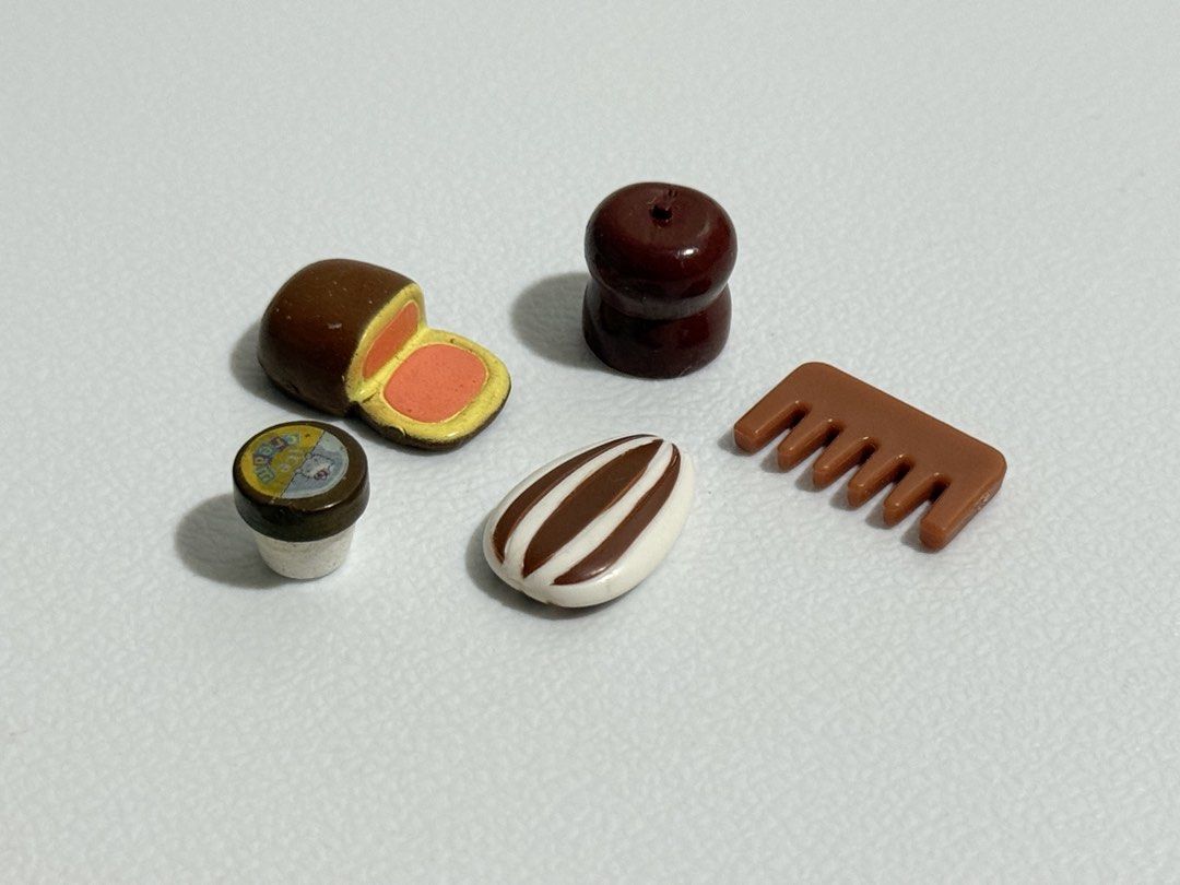 Sylvanian Families Assorted Brown Spares (Category: Kids Toys) located in Dasmarinas. Submitted by slowblinkshop (Listing ID 1442186460, Image 1). Description: - Miniature food toy set - Includes: chocolate bar, candy with filling, small cup with label, round object, and comb - Ideal for dollhouses and miniature collections - Small decorative items.