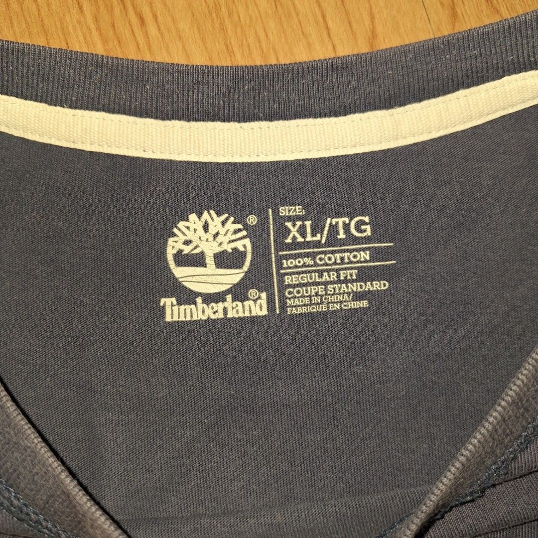 Timberland Big Logo (Category: Tshirts & Polo Shirts ) located in Aroroy. Submitted by rewear_r3volution (Listing ID 1442330139, Image 3). Description: This is a navy blue Timberland t-shirt featuring a prominent red tree logo on the chest. Size XL.