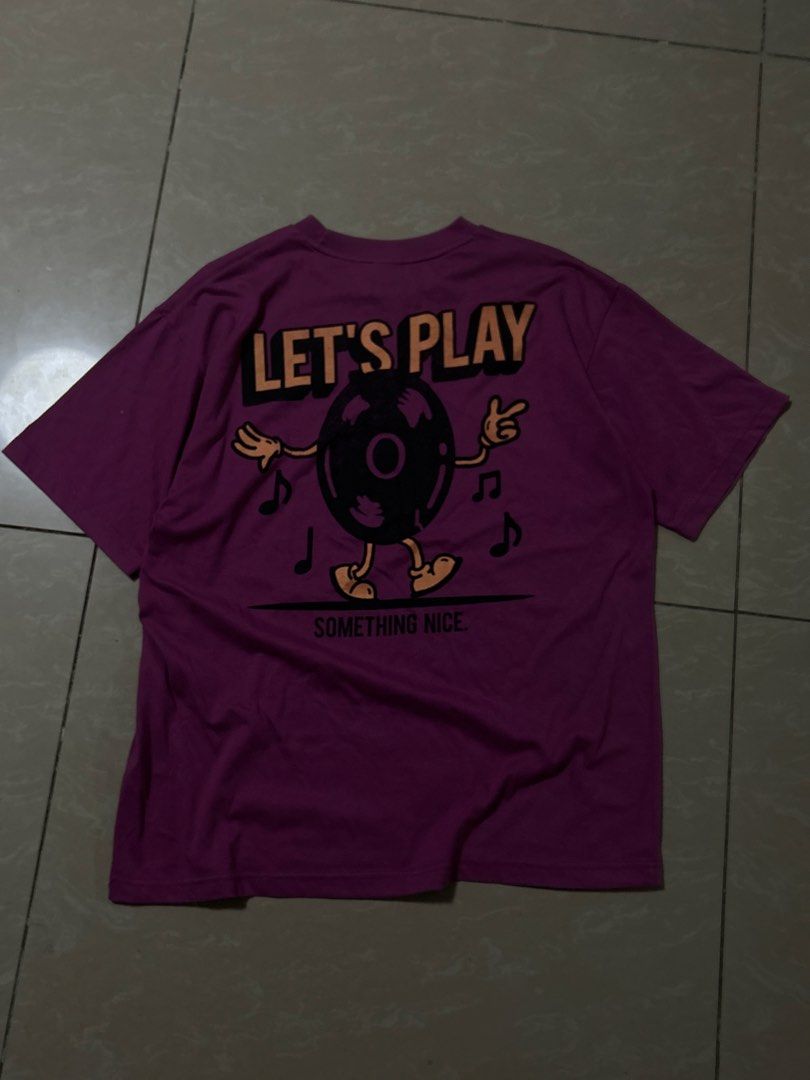 Vintage graphic purple shirt (Category: Tshirts & Polo Shirts ) located in Santa Rosa. Submitted by mandeclutterzzz (Listing ID 1442262549, Image 1). Description: Dimes: Width:20 inches Length:27 inches - Eye-catching purple t-shirt - Fun graphic on the back: a record character dancing with musical notes - Text on back: "LET'S PLAY SOMETHING NICE" - Small "LET'S PLAY" detail on the front chest - Classic short sleeves and crew neck design - Ideal 