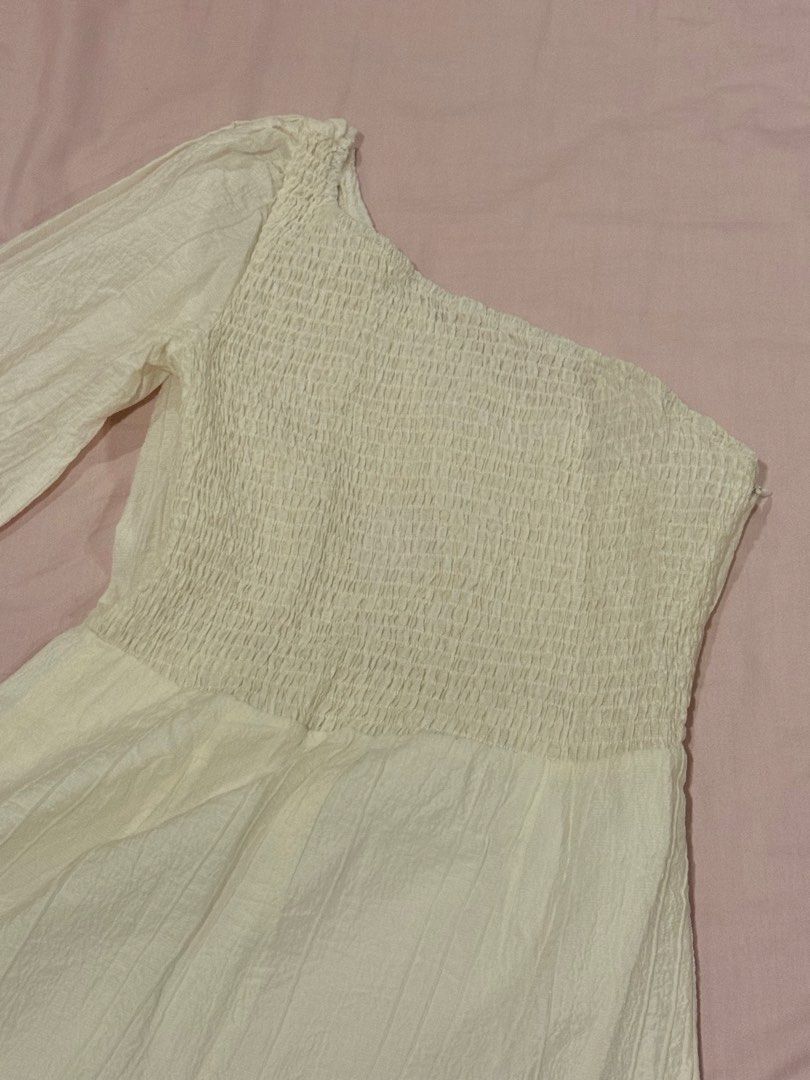 White One-Shoulder Smocked Romper with Puff Sleeve (Category: Rompers) located in Quezon City. Submitted by ellereve_ph (Listing ID 1442319774, Image 3). Description: - White one-shoulder romper - Smocked bodice for a comfortable fit - Features a stylish single puff sleeve - Textured fabric adds a unique touch - Convenient side zipper closure - Ideal for casual wear or beach trips.